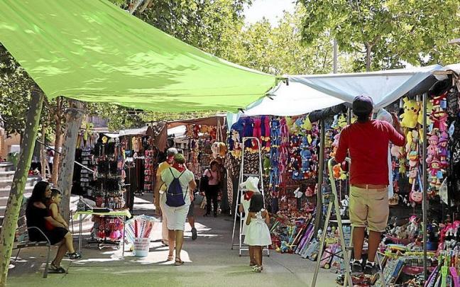 Uno de los vendedores recoloca un toldo en el paseo del Queiles.