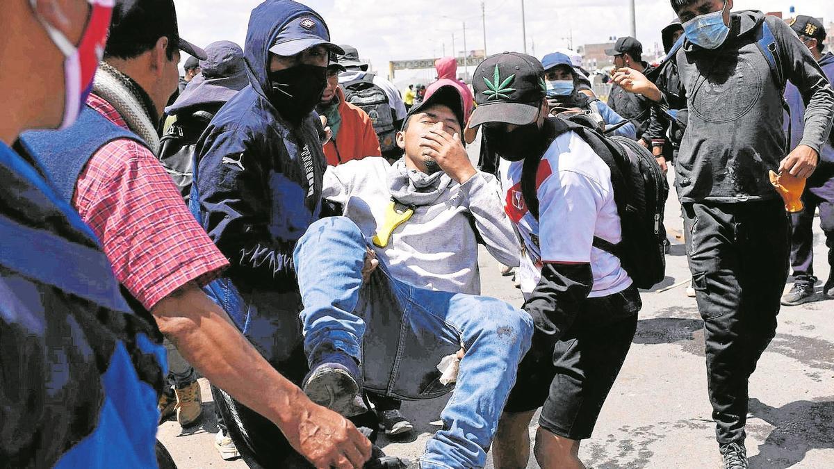 Un herido por los enfrentamientos entre los manifestantes y la policía en Juliaca es trasladado para ser atendido.