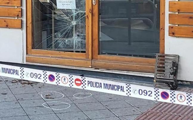 Puerta de cristal fracturada y la alcantarilla usada para romperla.