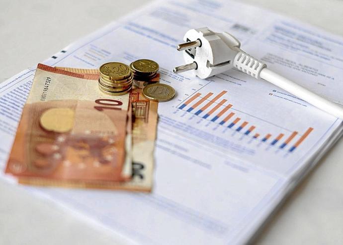 Un recibo de la luz, con dinero en metálico.