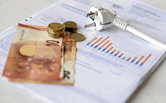Un recibo de la luz, con dinero en metálico. Un recibo de la luz, con dinero en metálico.