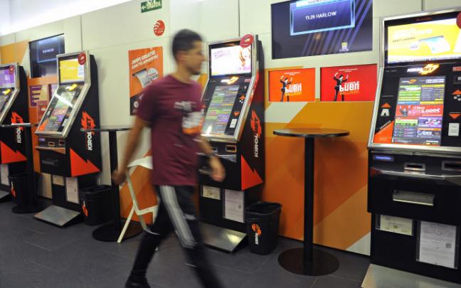 Un joven en un local de apuestas deportivas. Un joven en un local de apuestas deportivas.