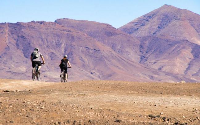 Una pareja de ciclistas circulan por una de las rutas que ofrece Lanzarote. Una pareja de ciclistas circulan por una de las rutas que ofrece Lanzarote.