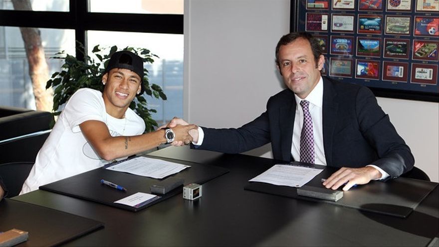 El jugador Neymar con Sandro Rosell firmando el contrato.