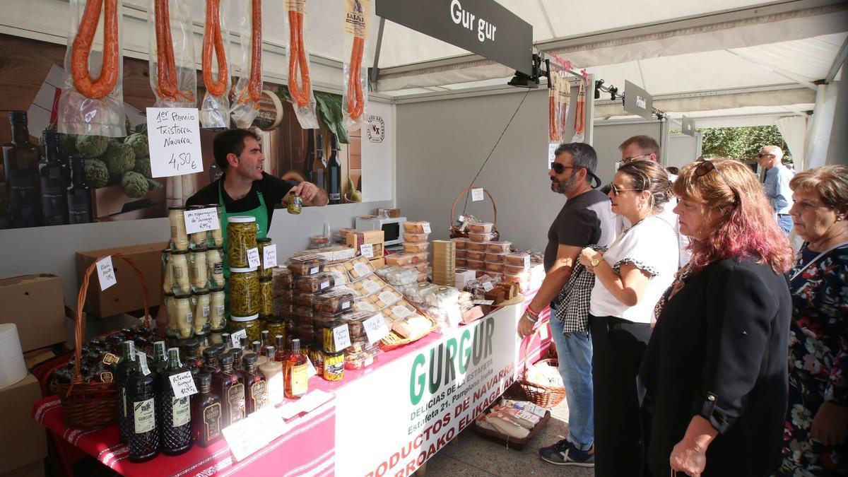 Natxo Ainzua, de la tienda de artesanos Gur-Gur, explica a los clientes los productos que ofrece en el puesto.