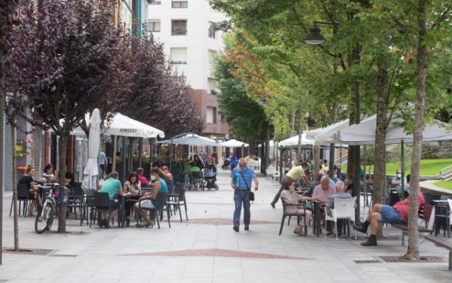 Una calle con varias terrazas de bares y cafeterías. Una calle con varias terrazas de bares y cafeterías.