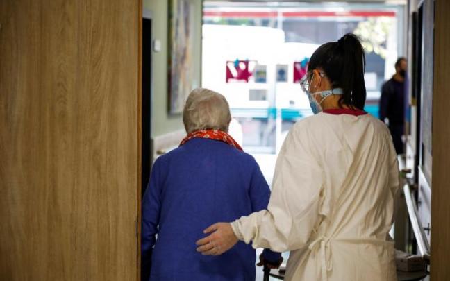 Una trabajadora acompaña a una anciana en una residencia de mayores. Una trabajadora acompaña a una anciana en una residencia de mayores.