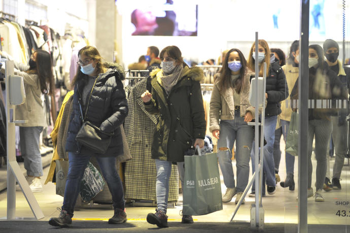 Un grupo de personas realizando compras en un comercio.