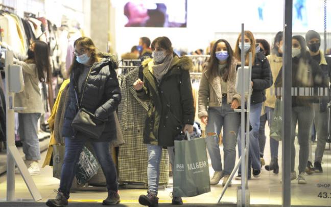 Un grupo de personas realizando compras en un comercio.