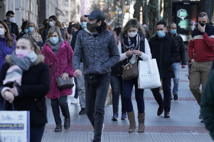 Gente paseando con mascarilla por una calle.