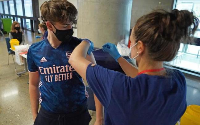 Un joven recibe una dosis de la vacuna de Pfizer.