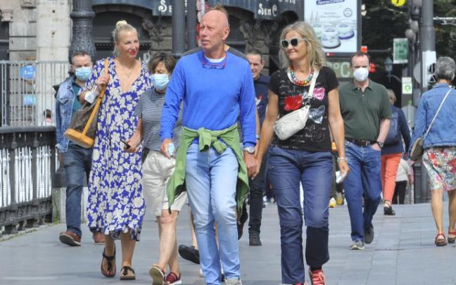 Varias personas pasean por la calle.