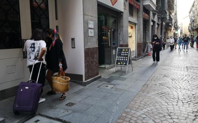 Dos jóvenes acceden a un piso turístico.