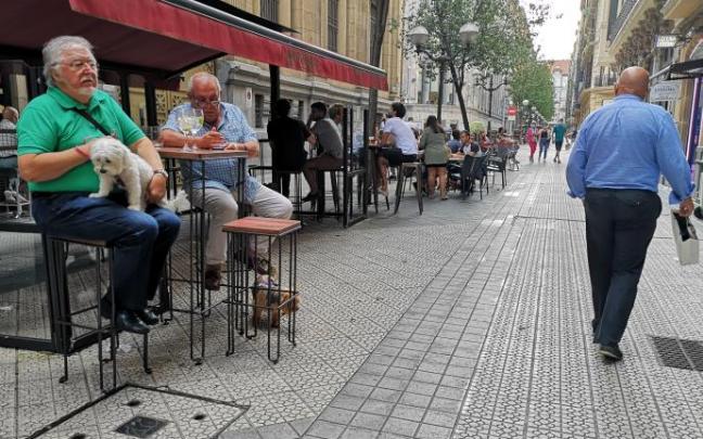 Varias personas en terrazas de establecimientos hosteleros.