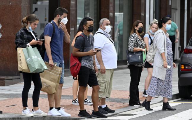 Personas paseando por la calle con mascarilla. Personas paseando por la calle con mascarilla.