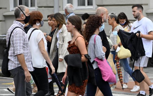 Varias personas caminan por una calle.