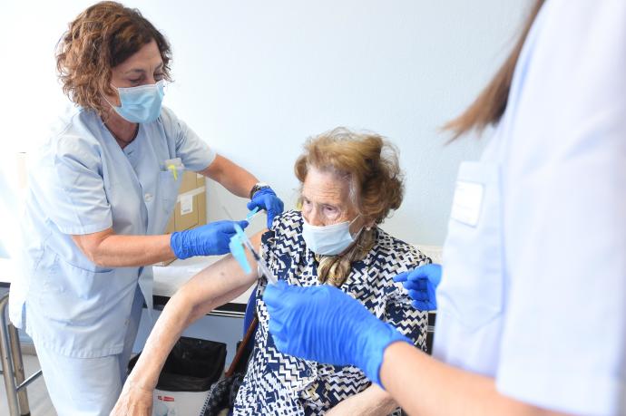 Una mujer recibe la vacuna de la gripe.