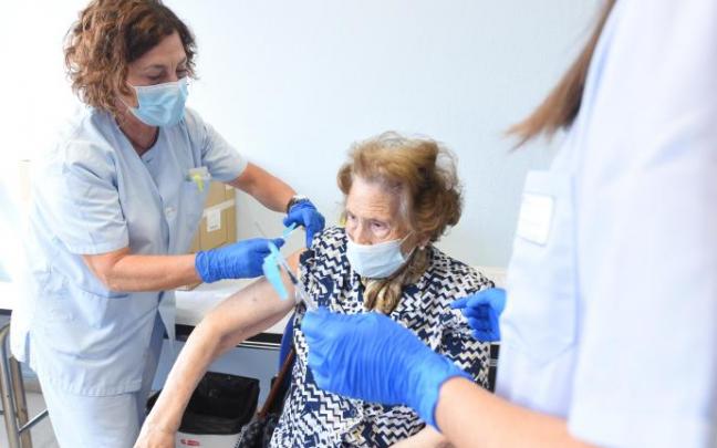 Una mujer recibe la vacuna de la gripe.