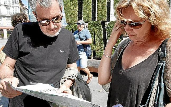 Varios turistas planifican, mapa en mano, su recorrido por la capital alavesa. El sector hotelero espera aumentar su número durante las fiestas de la Blanca | FOTO: PILAR BARCO