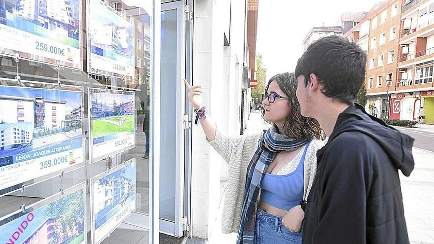 Dos jóvenes miran el escaparate de una inmobiliaria. | FOTO: J. M. MARTÍNEZ