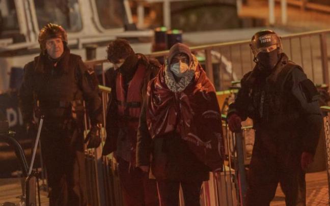 Policías, junto a varios migrantes en Dover. Policías, junto a varios migrantes en Dover.