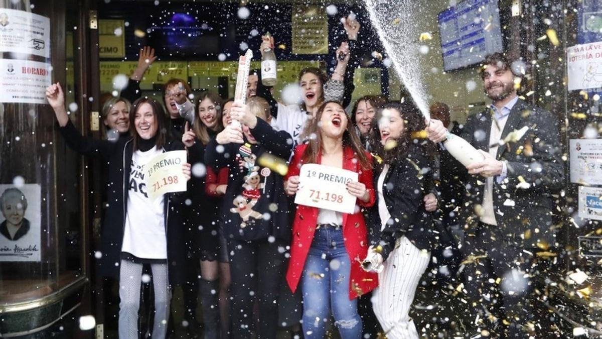 Celebración junto a la puerta de una administración de lotería.