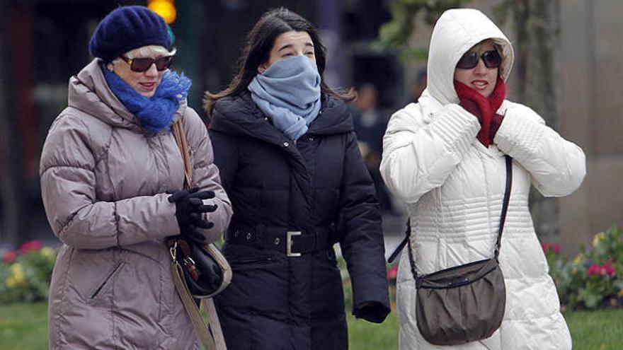 Tres mujeres se resguardan del frío