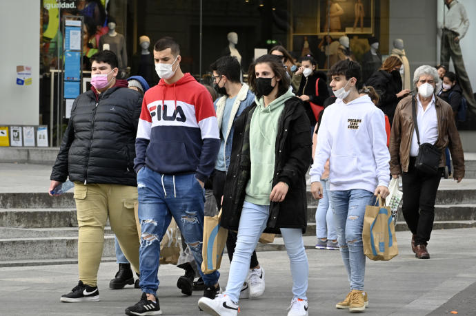 Un grupo de personas, paseando con mascarilla.