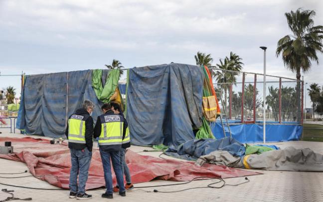Dos policías inspeccionan el castillo hinchable en el que murieron dos menores.
