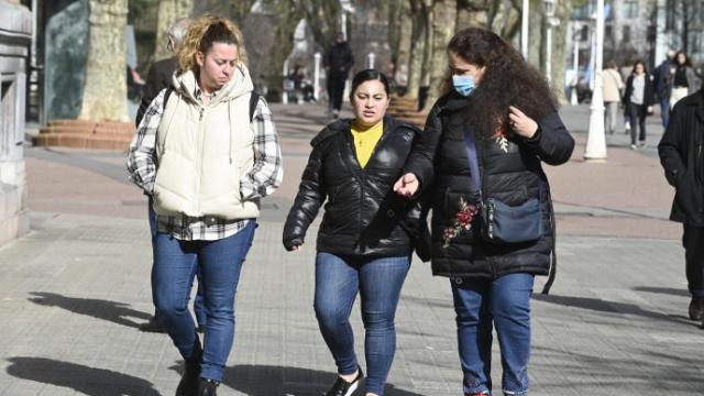 Tres chicas pasean por una calle.