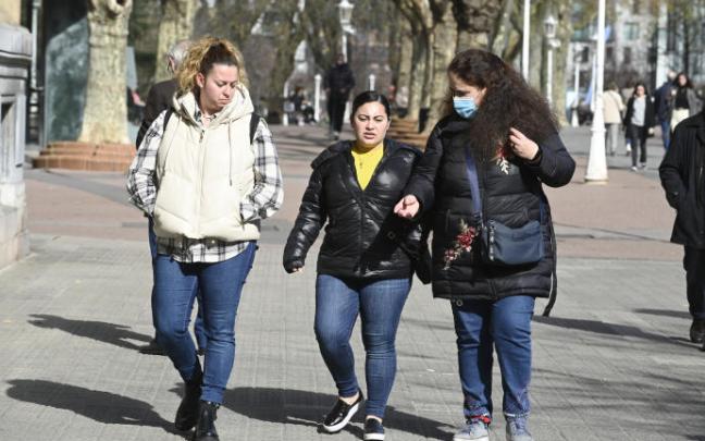 Tres chicas pasean por una calle.