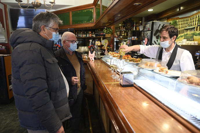 Clientes de un bar con mascarilla.