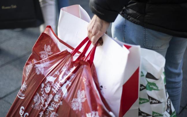 Una mujer pasea con varias bolsas de compra. Una mujer pasea con varias bolsas de compra.