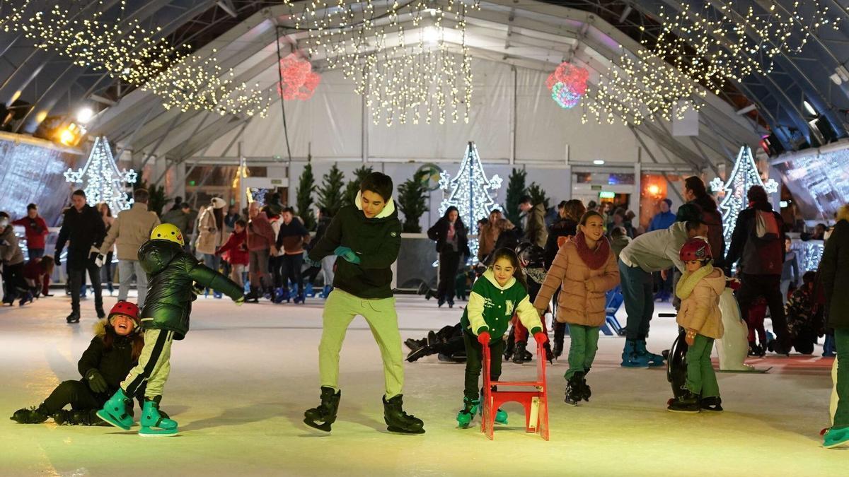 Un grupo de niños y niñas patina en la pista de hielo.