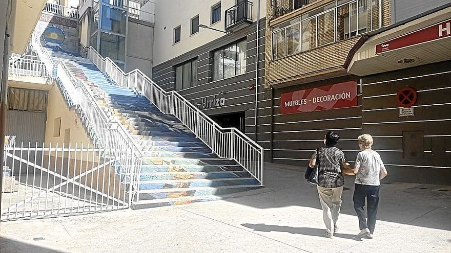 Dos mujeres miran el desnivel que las separa de la calle La Corte en el barrio de Lizarra.