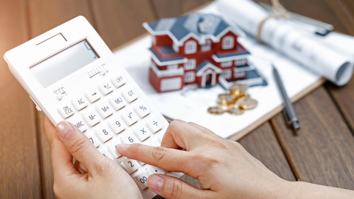 Una persona hace cuentas sobre su préstamo hipotecario con una calculadora.