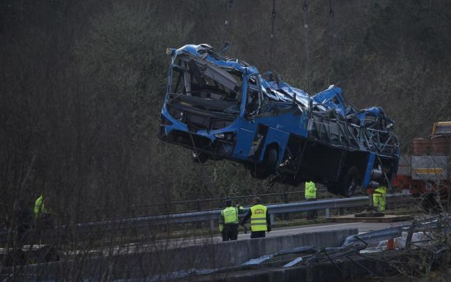 Una grúa coloca el autobús accidentado sobre el puente para sacarlo del cauce del río Lérez Una grúa coloca el autobús accidentado sobre el puente para sacarlo del cauce del río Lérez