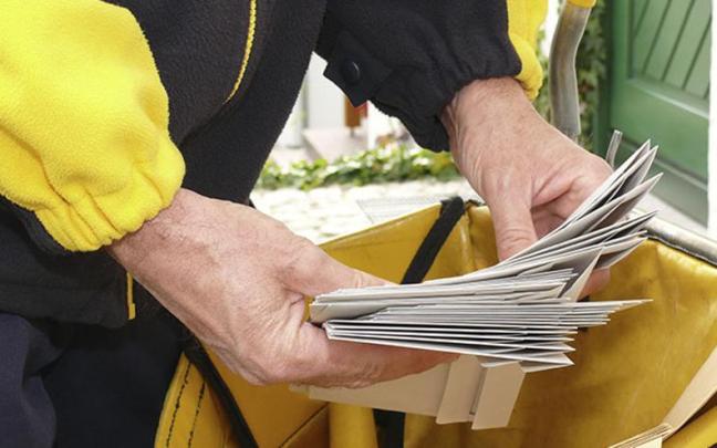 Un cartero lleva el correo a un domicilio Un cartero lleva el correo a un domicilio