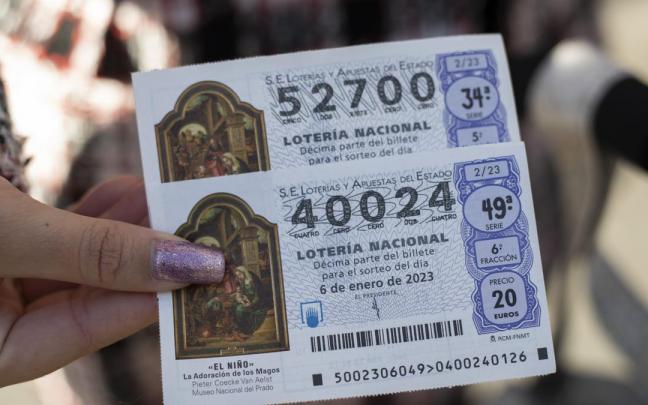 Una mujer sostiene dos décimos de la Lotería del Niño Una mujer sostiene dos décimos de la Lotería del Niño