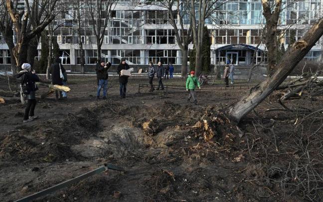 Varias personas obserban el cráter dejado por un misil en Kiev. Varias personas obserban el cráter dejado por un misil en Kiev.