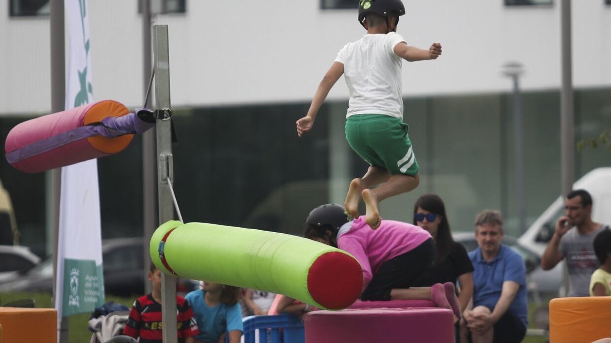 Varios niños juegan en un parque infantil.