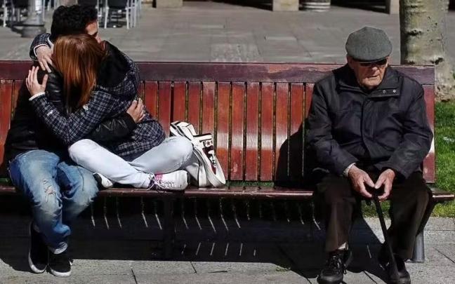 Una pareja de j&oacute;venes se abraza junto a una persona mayor