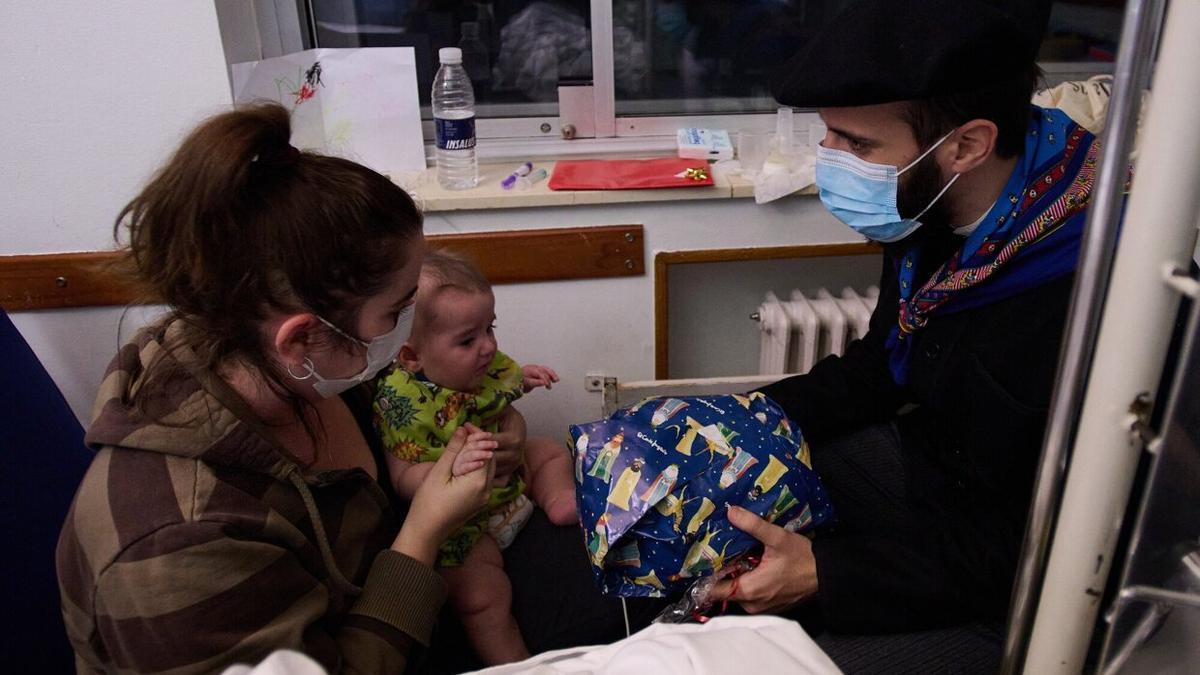 Olentzero entrega un regalo a un bebé que se encontraba en la planta de hospitalización.