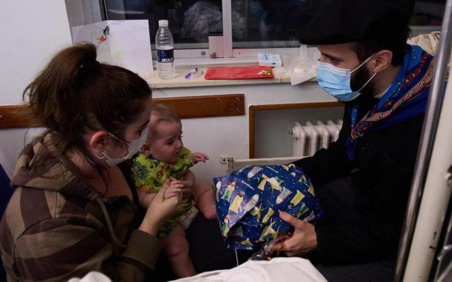 Olentzero entrega un regalo a un bebé que se encontraba en la planta de hospitalización.