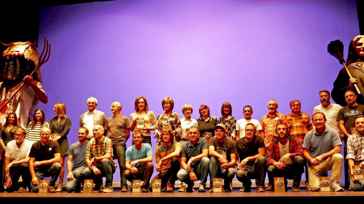 Foto de familia de todas las personas premiadas en la gala entre Momotxorro y Sorgiña, los principales personajes del carnaval de Altsasu.