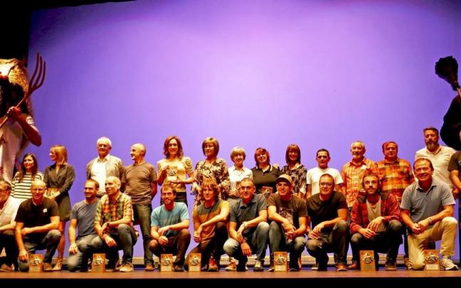 Foto de familia de todas las personas premiadas en la gala entre Momotxorro y Sorgiña, los principales personajes del carnaval de Altsasu.