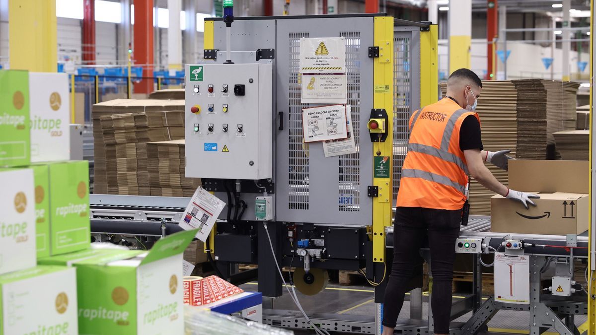 Un trabajador de Amazon prepara un pedido, en una caja de cartón.
