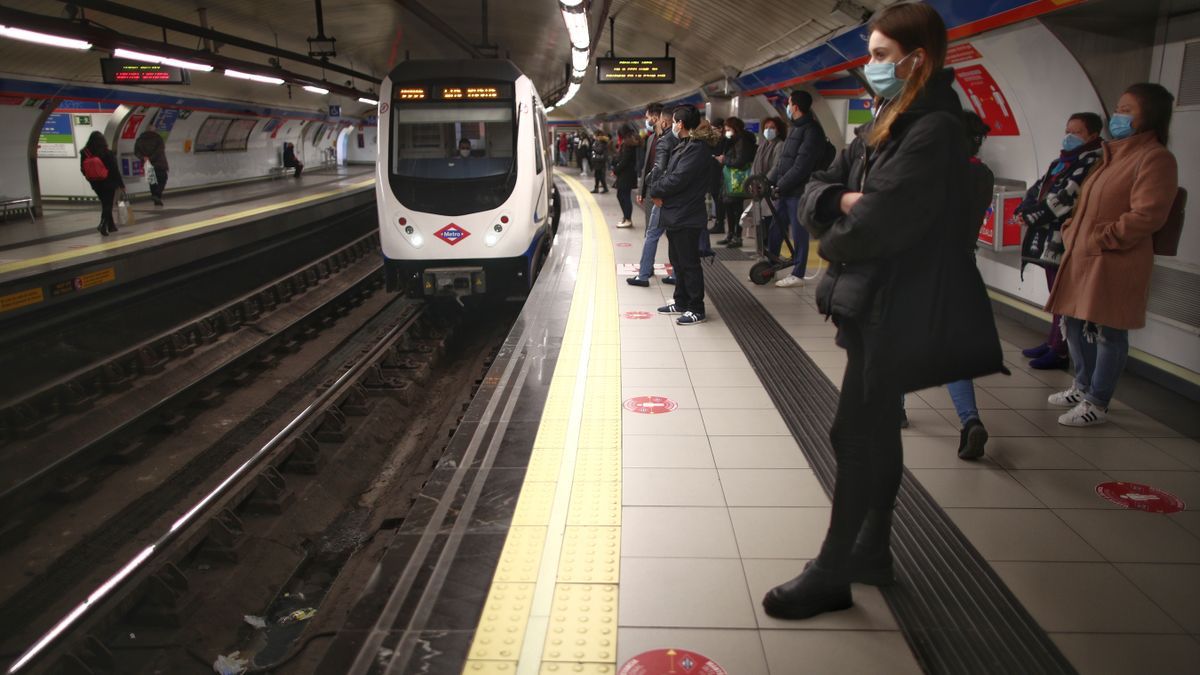 Varios pasajeros esperan en un andén del metro de Madrid.