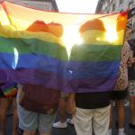 Dos personas se tapan con una bandera durante una manifestaci&oacute;n por el Orgullo LGTBI.