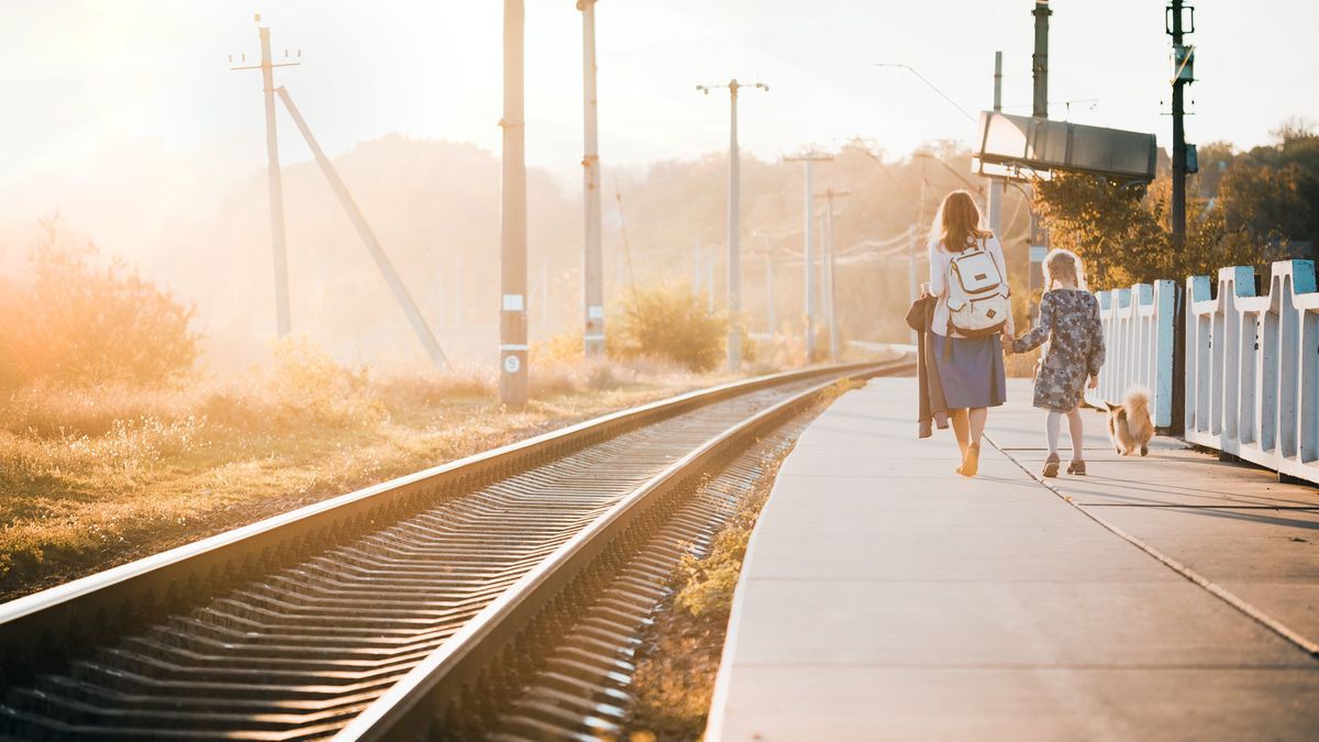 Una mujer y su hija abandonan con su perro una estación de tren.